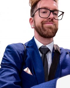 Scott Lantow headshot at Technology repair expo in blue business suit with black tie