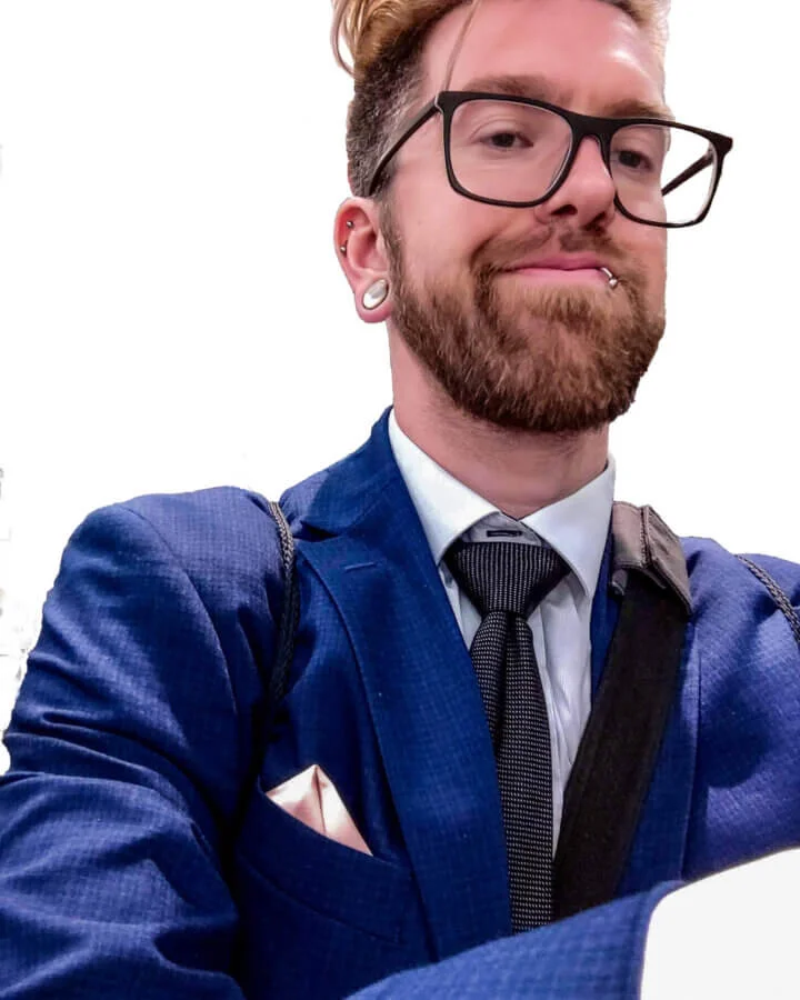 Scott Lantow headshot at Technology repair expo in blue business suit with black tie