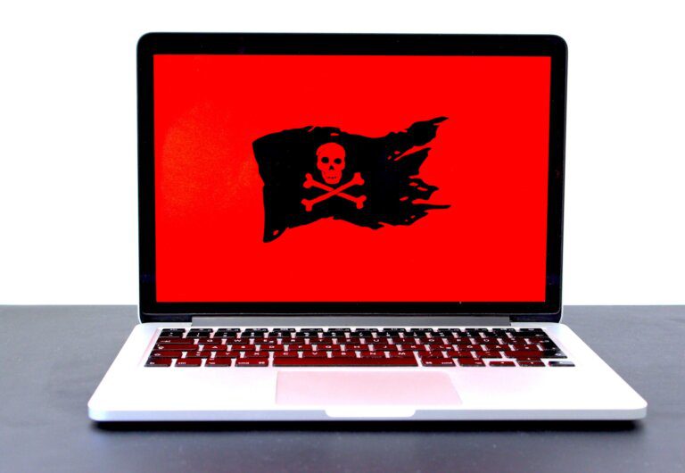 MacBook Pro turned-on with ransomware jollyrogger flag on screen ready to clean up virus repair remote attack scammer for business or residential customer
