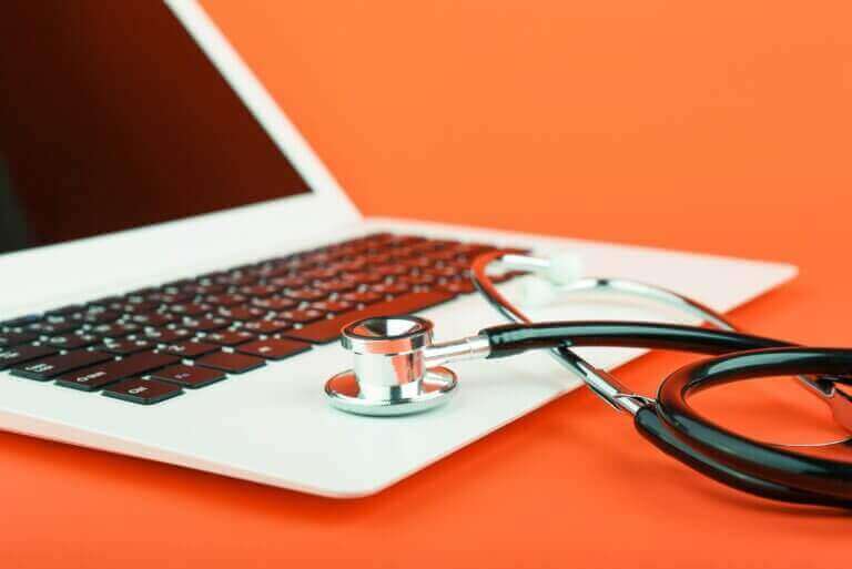 Photo of macbook laptop with doctor stethoscope on palmrest symbolizing computer repair diagnostics needed for computer repair