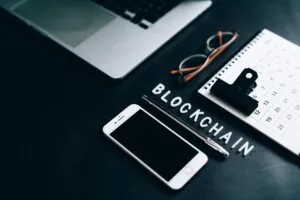 Stock photo for my what is blockchain article. Free Flat lay of a modern digital workspace with blockchain theme, featuring a smartphone and calendar.